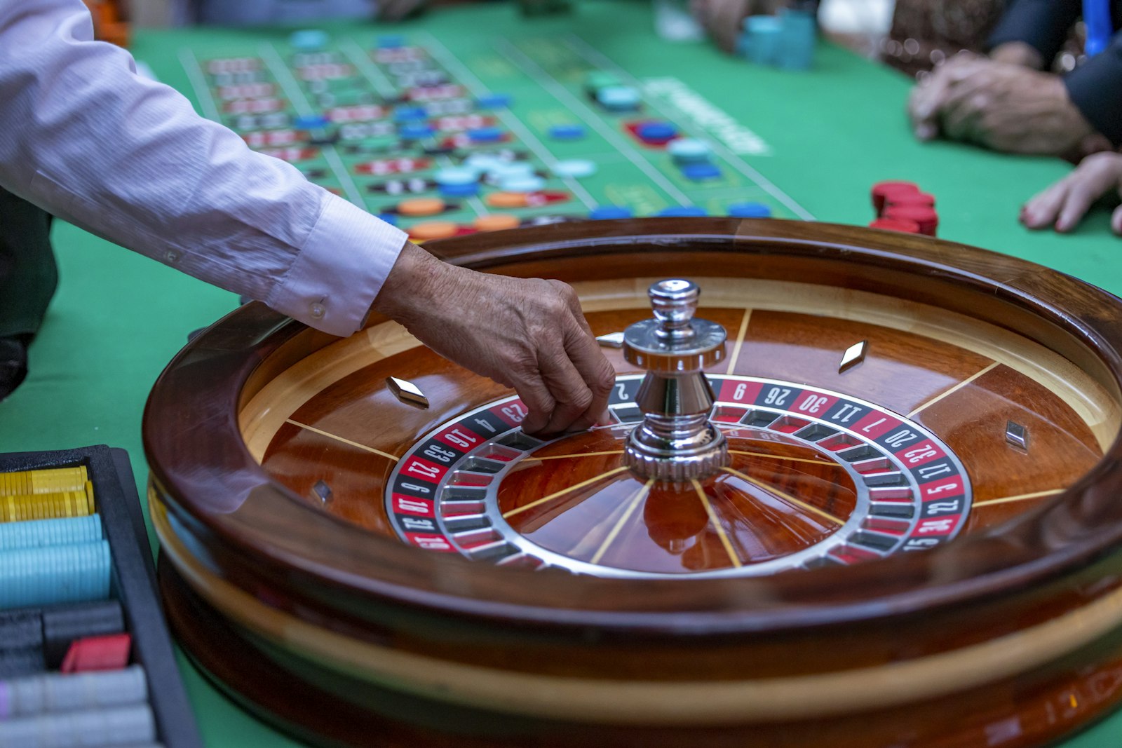 A croupier's hand on a roulette wheel
